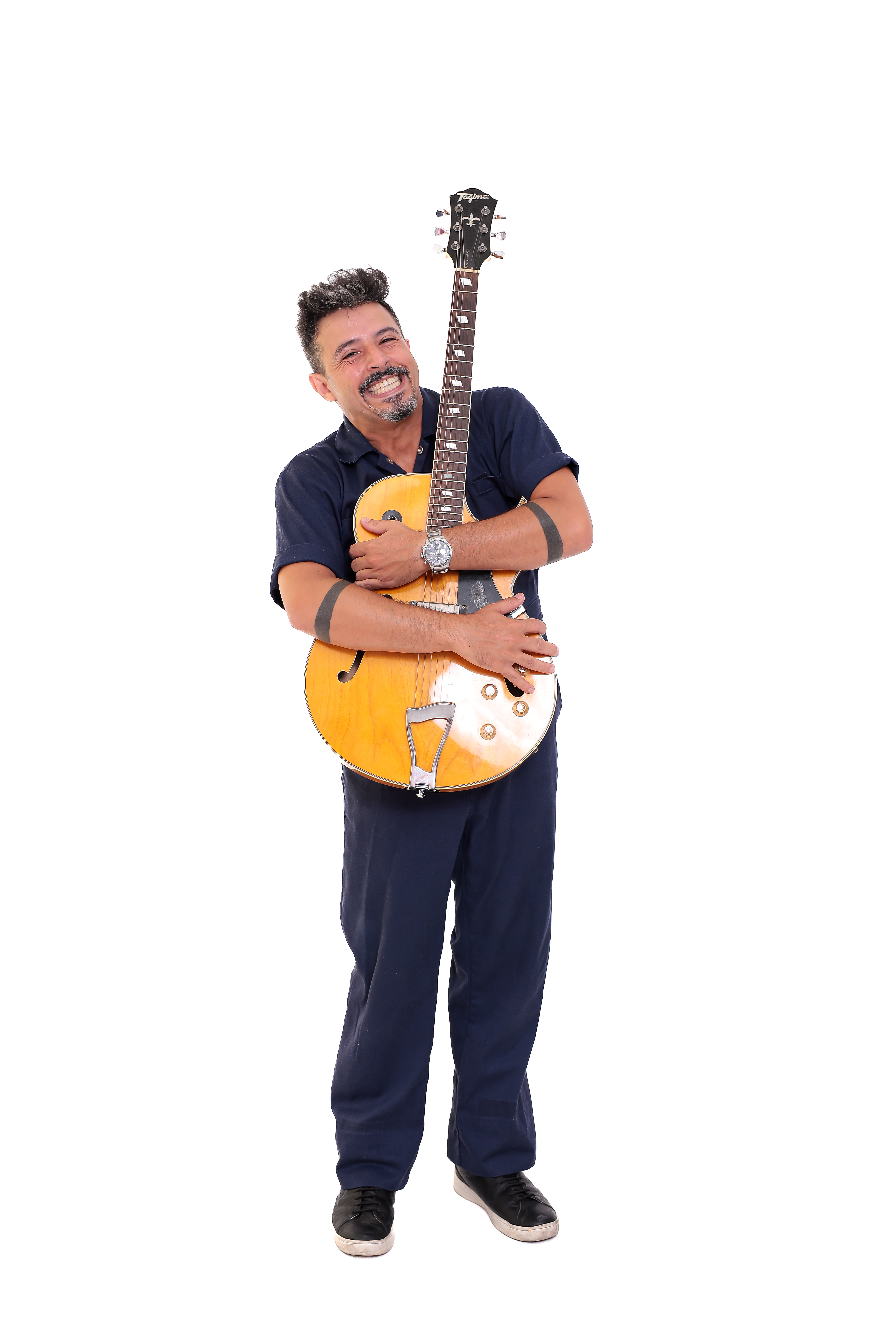 Rick Minervino abraçando a guitarra e sorrindo
